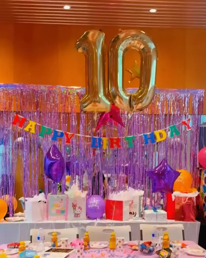 Cirque Art Studio North Miami birthday party rental space setup with gold 10 balloons, purple backdrop, and festive table.